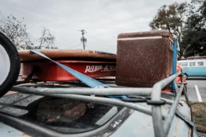 Rusty vintage cooler strapped to car roof rack with Radio Flyer wagon — inspiration for best car cooler for road trips