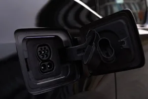 Open EV charging port on vehicle showing Type two inlet and cover, illustrating EV charger compatibility with RV outlet