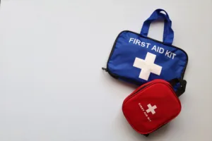 Blue and red portable first aid kits with white cross on light background, compact travel emergency kits for road trips