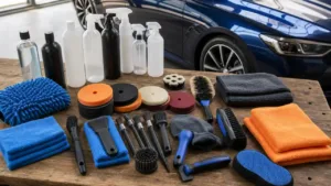 Car detailing kit with microfiber towels brushes and plain bottles on a workbench